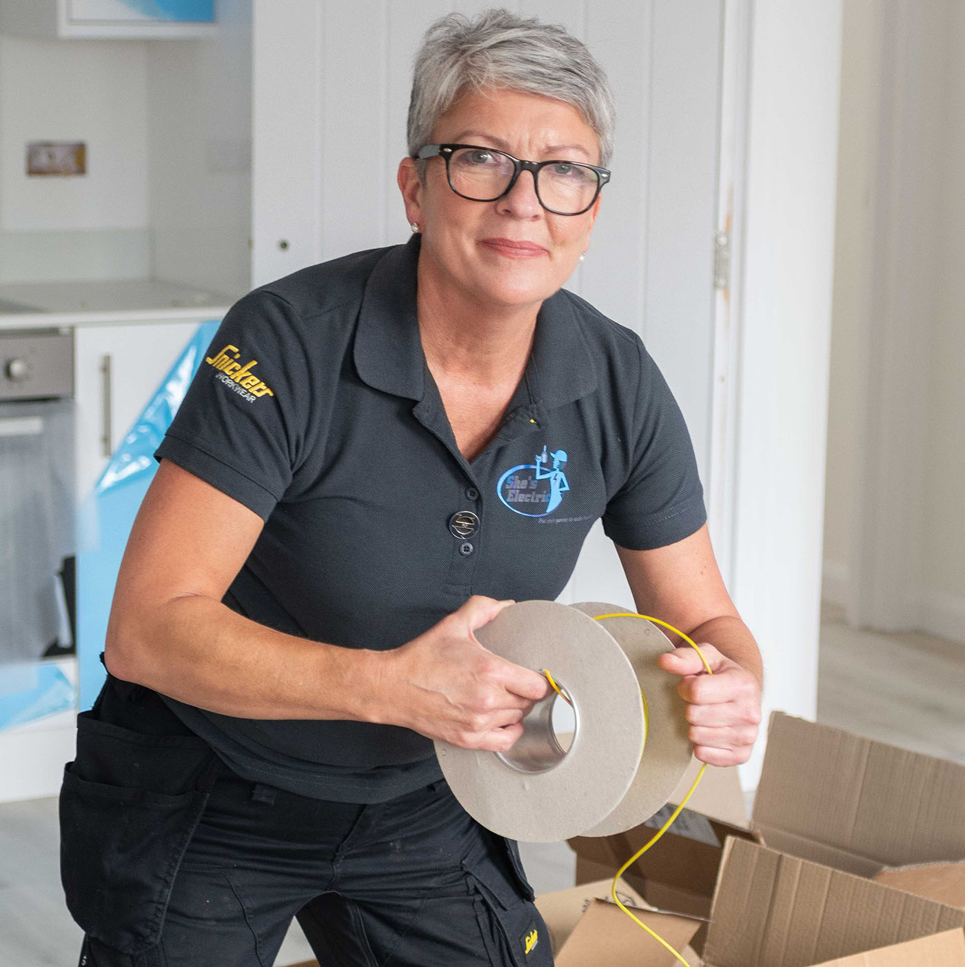 Cooker and Hob Services this image shows Karen unrolling electrical wire